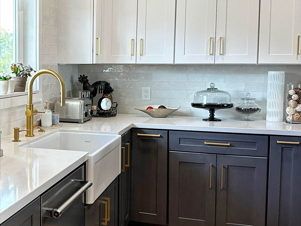 Renovated kitchen with refurbished cabinets, ceramic countertop and a sink with brass faucet